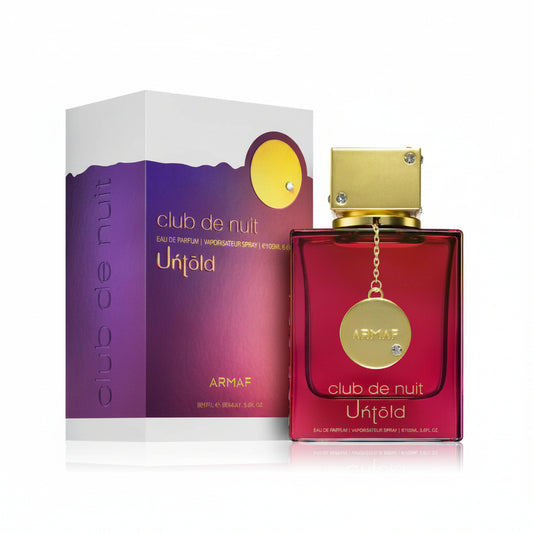 A product image featuring a bottle of ARMAF CLUB DE NUIT UNTOLD perfume with a purple box in the background. The bottle is red with a gold cap, and there is a diamond-shaped pendant attached to the cap.